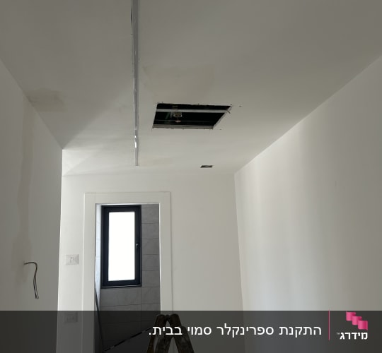 סולם עומד בחדר עם תקרה פתוחה